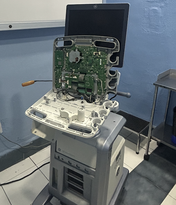 Equipo de ultrasonido sobre carro con la cubierta posterior retirada durante servicio técnico