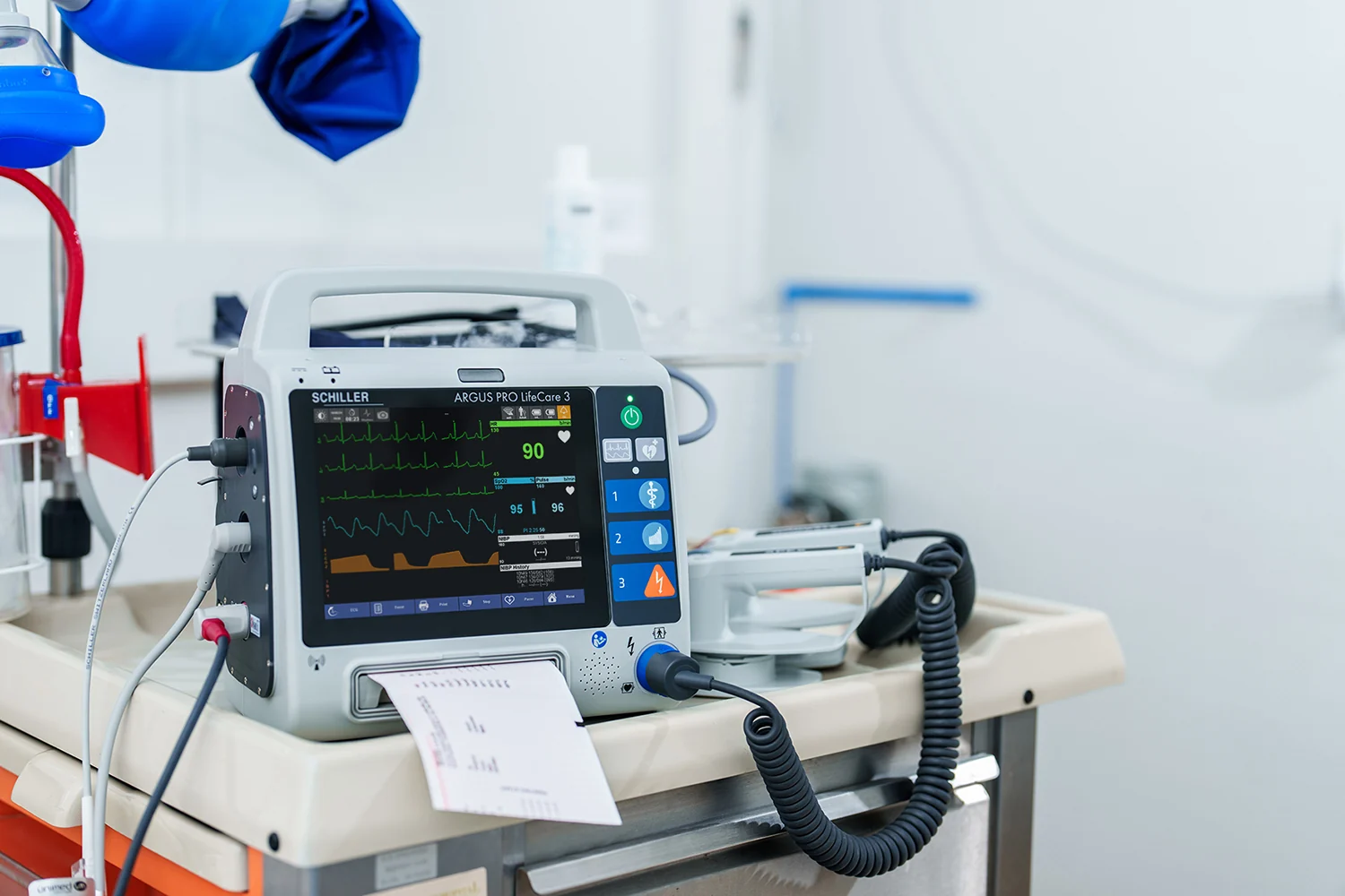 Monitor desfibrilador SCHILLER ARGUS PRO LifeCare 3 sobre una mesa hospitalaria con cables conectados